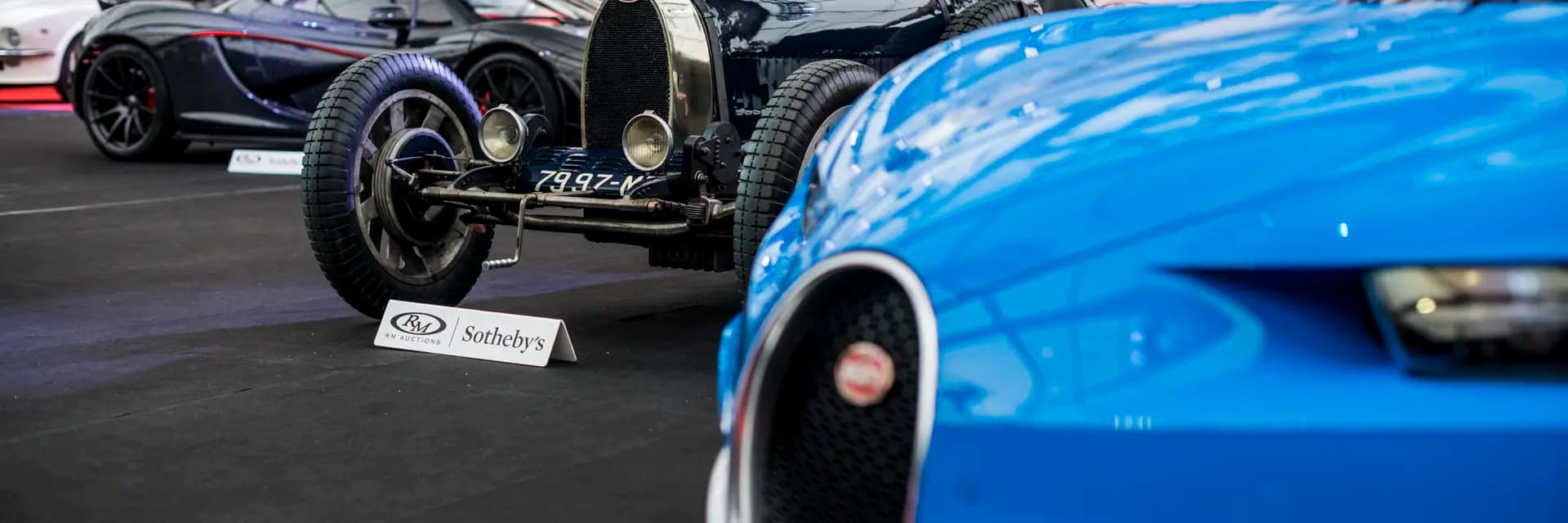 Luxury cars at auction with Bugatti display